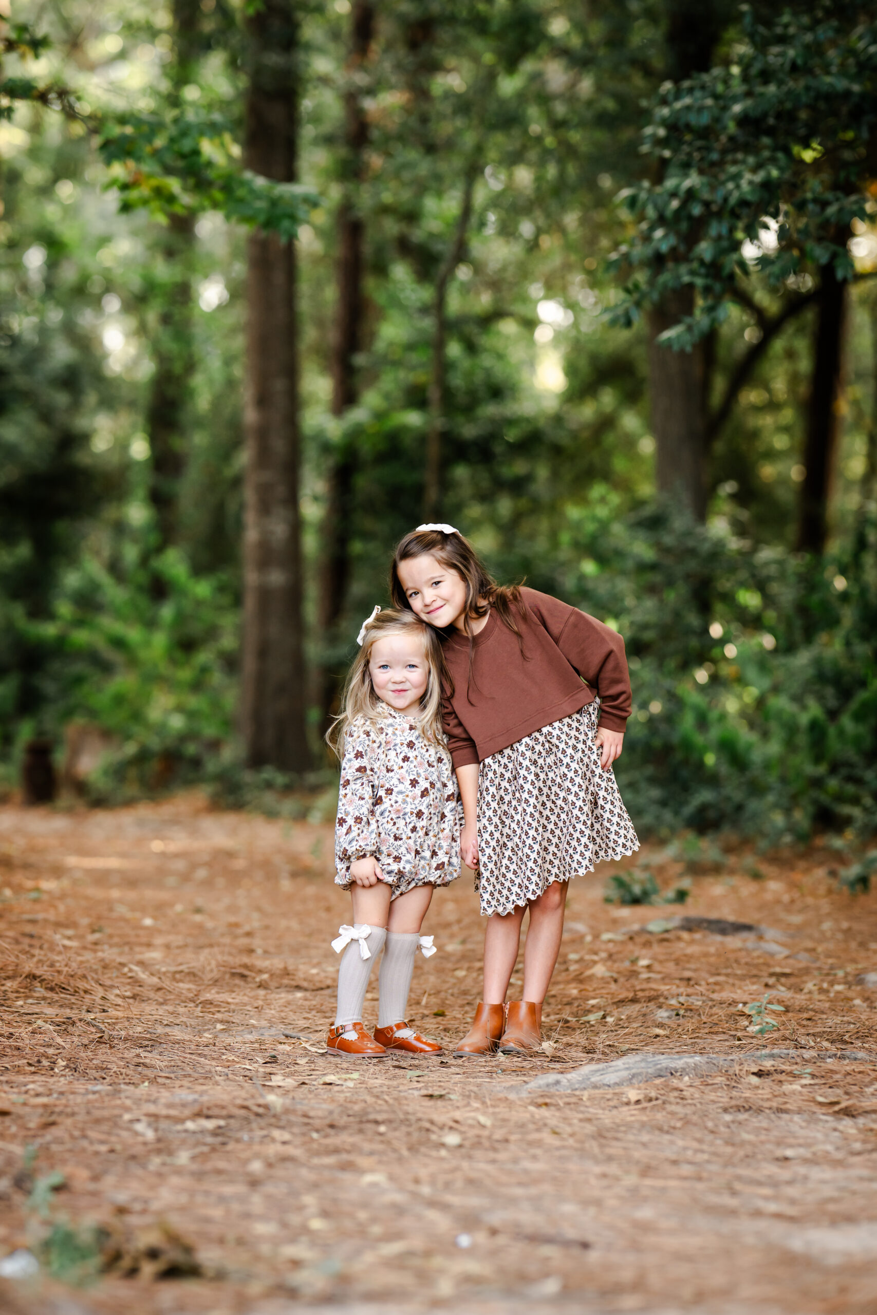 A picture of two sisters in a forest in The Woodlands, Texas.