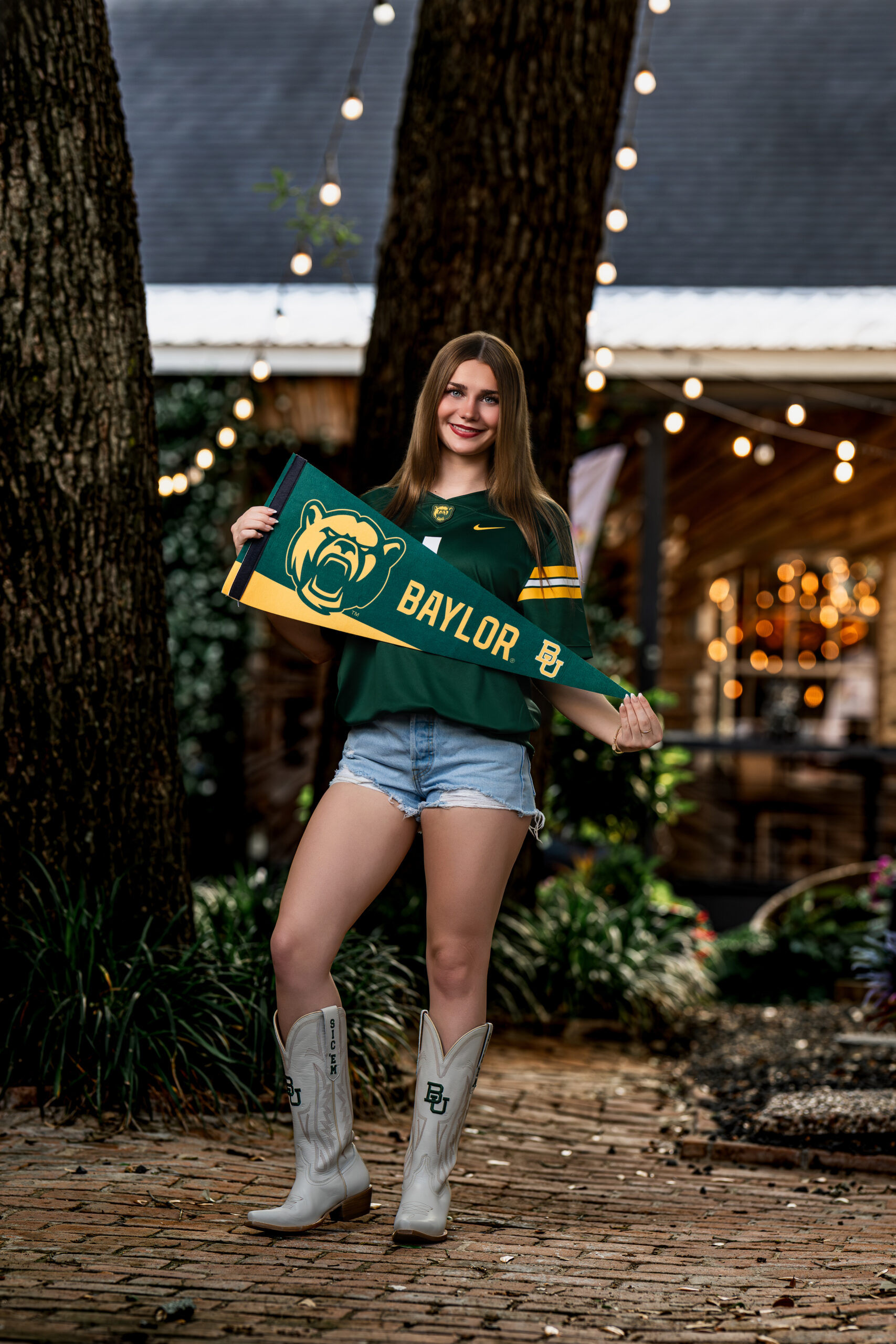 A picture of a senior high school student standing in front of an old vintage building in Old Town Spring, Texas.