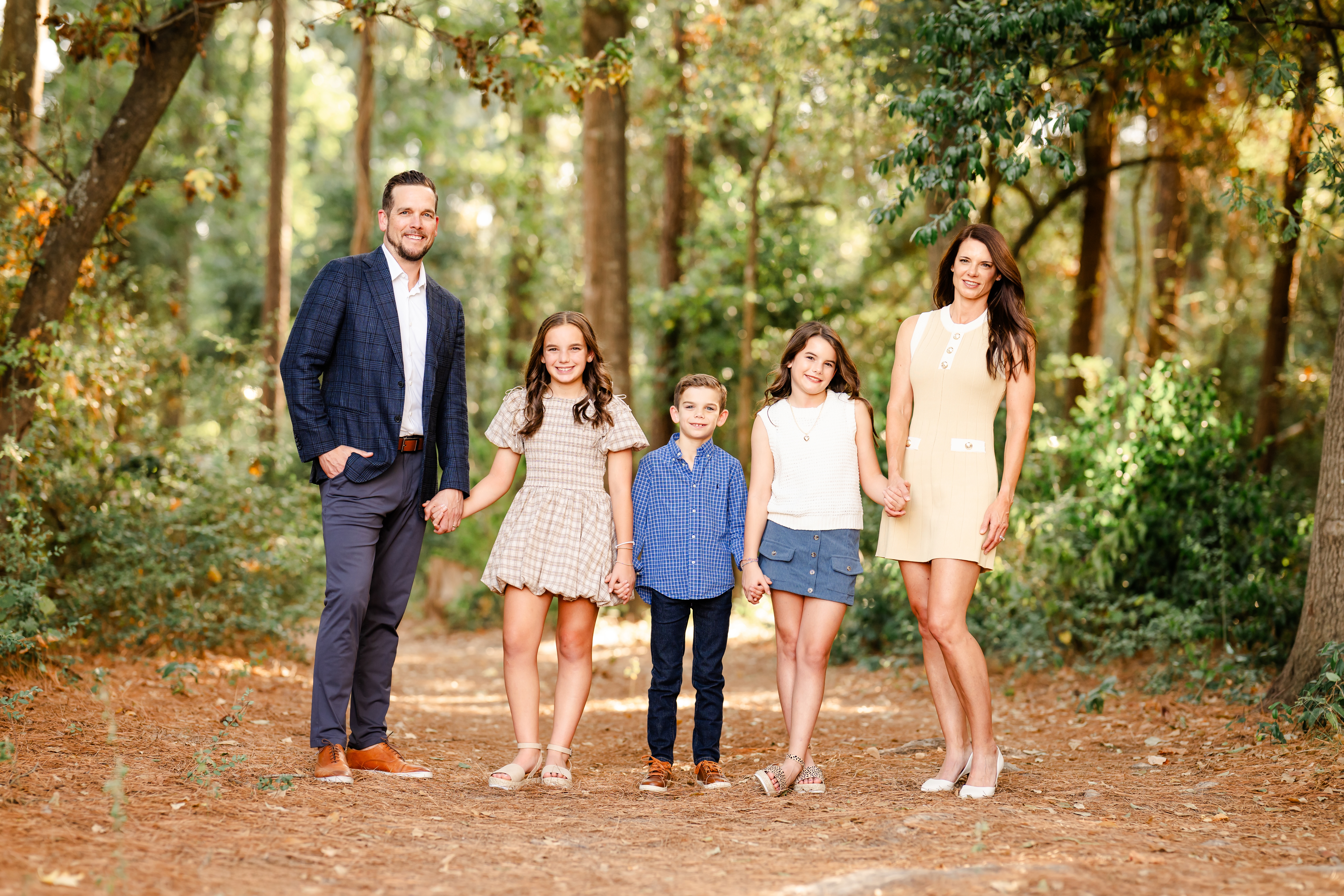Picture of a family of five posing for their Fall family photo session near Panther Creek in The Woodlands, Texas.