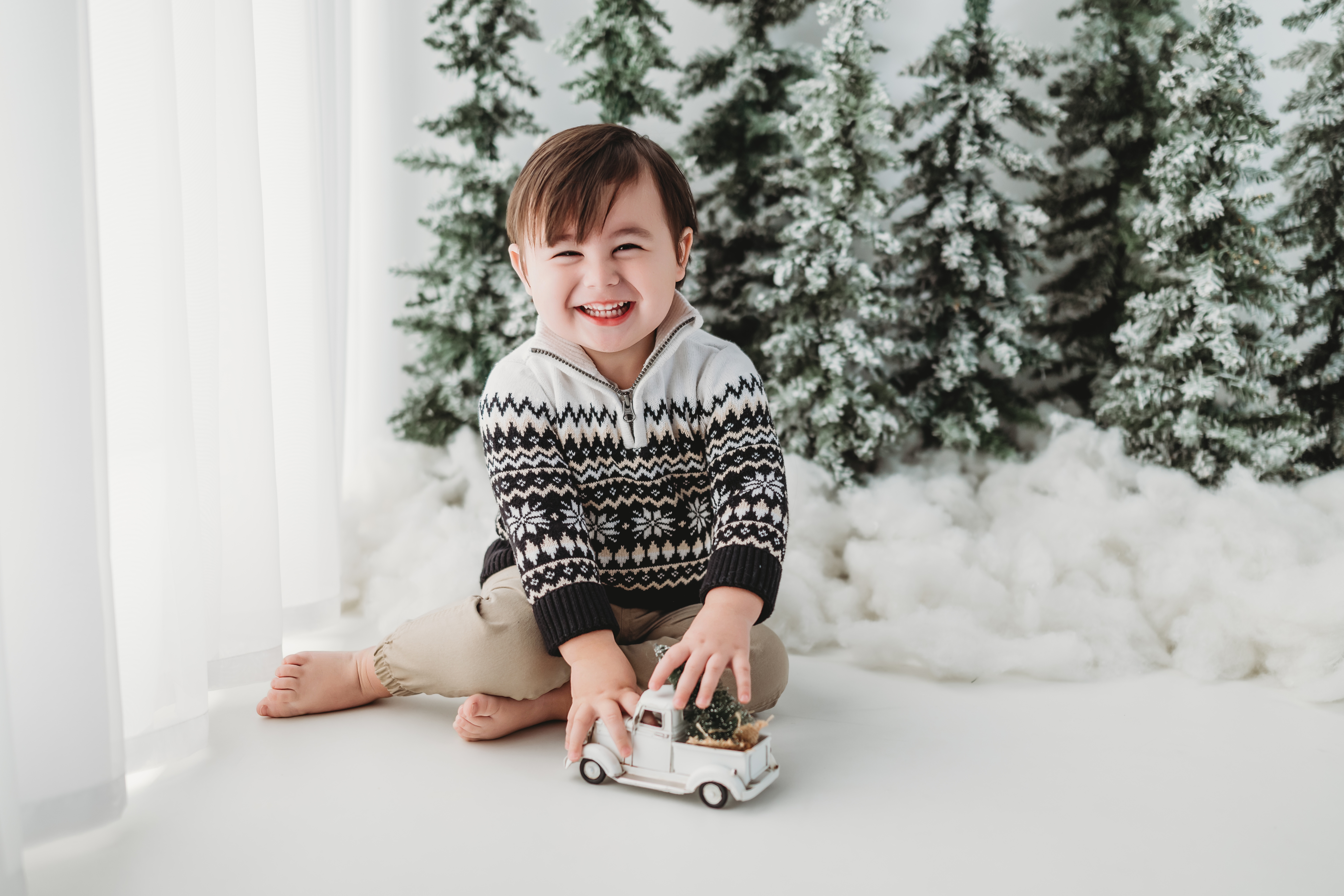 Picture of a young boy posing for his Christmas photo session near Panther Creek in The Woodlands, Texas.