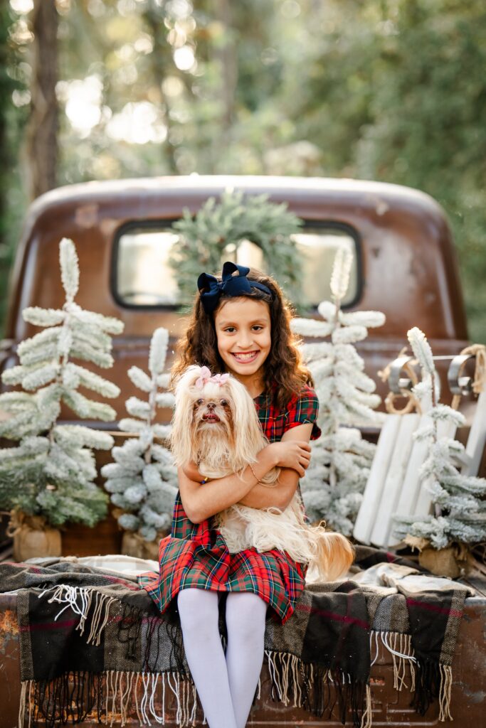 Picture of a girl and her pet dog during a Christmas min photo session in The Woodlands, Texas.